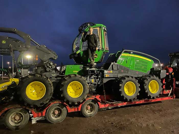 Traktor med släp fullt med stockar